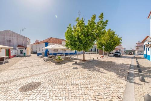 a cobblestone street with a tree in a town at GuestReady - Enchanting retreat in Alcácer do Sal in Alcácer do Sal