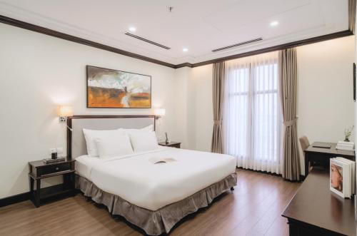 a hotel room with a large white bed and windows at CityHouse - Atelier Thảo Điền in Ho Chi Minh City