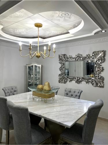 a dining room with a table and a chandelier at Casa Norte Exclusive Home-Amplia, amoblada Valledupar in Valledupar