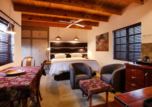 a bedroom with a bed and a table and chairs at Waterkloof Apartments in Pretoria