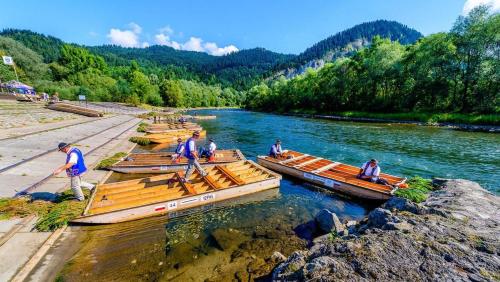a group of boats on a river with people on them at Domki Perła Białki z Jacuzzi in Białka Tatrzańska