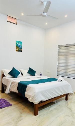 a bedroom with a large bed with blue pillows at CloudNine Stay in Sultan Bathery