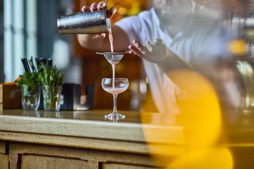 a person pouring a drink into a glass at The Old Bridge in Huntingdon