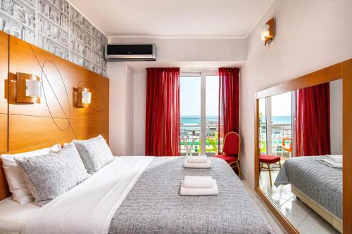a bedroom with a large bed with red curtains at City Life Port Hotel in Heraklio