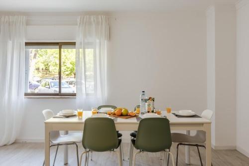 a white dining room with a table and chairs at 3BR Comfort & Convenience apt in central Massamá in Queluz