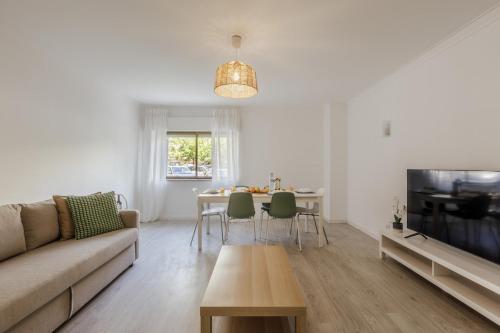 a living room with a couch and a table at 3BR Comfort & Convenience apt in central Massamá in Queluz