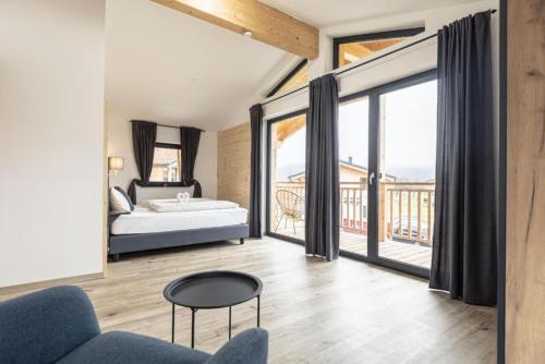 a bedroom with a bed and a large window at Luxalps- BergZeit- Inzell- Sommerpool- Sauna- Wandern- Chiemgau Card in Inzell