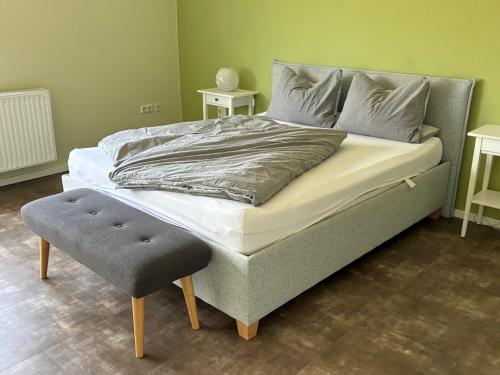 a bedroom with a large bed with a ottoman and a bed at Landidyll in Uelzen