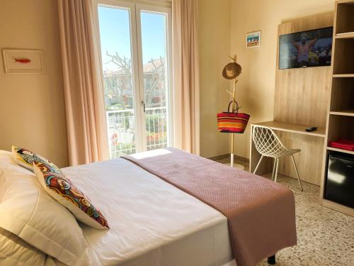 a bedroom with a bed and a large window at Hotel Garden B&B in Marotta