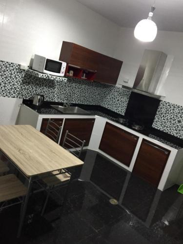 a kitchen with a wooden table and a microwave at Apinsaya House in Ban Pa Sang (1)