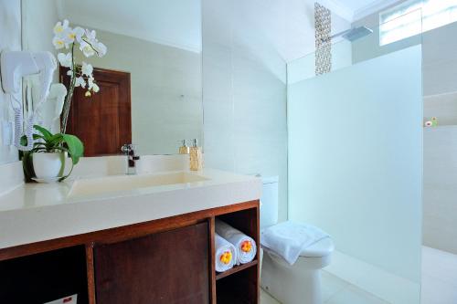 een badkamer met een wastafel en een spiegel bij Dewi Sri Hotel in Legian