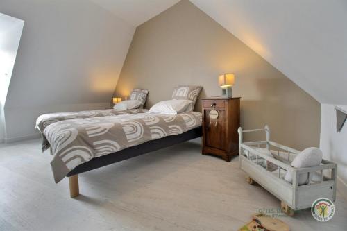 a bedroom with a bed and a crib in a attic at Ker'luane in Lézardrieux