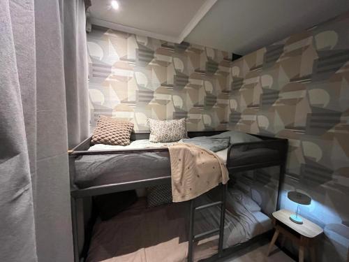 a bedroom with a bunk bed with a wall covered in wallpaper at La Vida in Lanaken