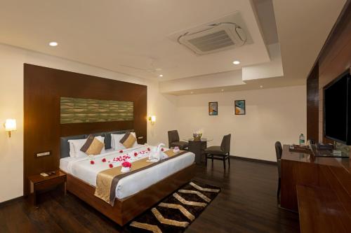 a hotel room with a large bed and a desk at Hotel Hemaadri Grand in Hyderabad