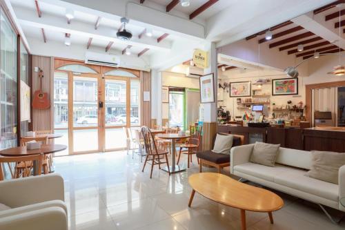 a restaurant with tables and couches and a bar at Samer Boutique Stay in Bangkok