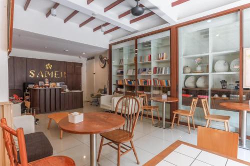 a restaurant with tables and chairs in a room at Samer Boutique Stay in Bangkok