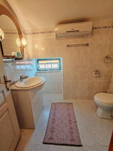 a bathroom with a sink and a toilet at Stone House - Waterfalls, Nature Stay in Louriçal do Campo