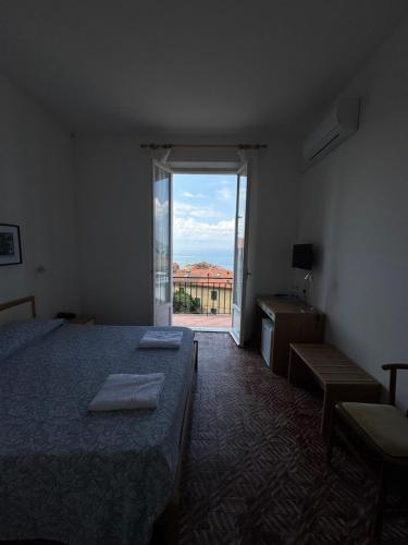 a bedroom with a bed and a large window at Miramaretellaro in Tellaro