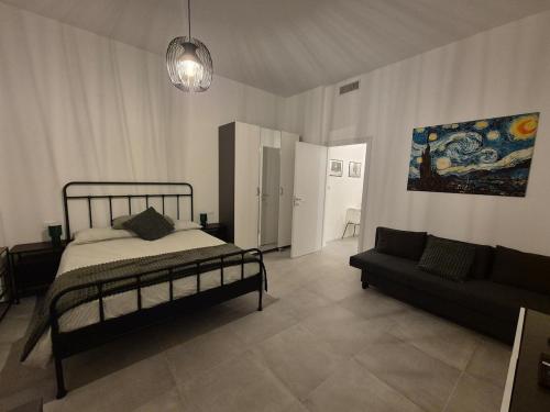 a bedroom with a bed and a couch at Casetta della Lupa in Cernusco sul Naviglio