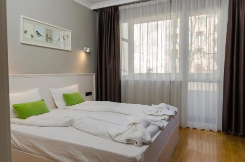 a white bed in a room with a window at VIP Apartments Sofia in Sofia