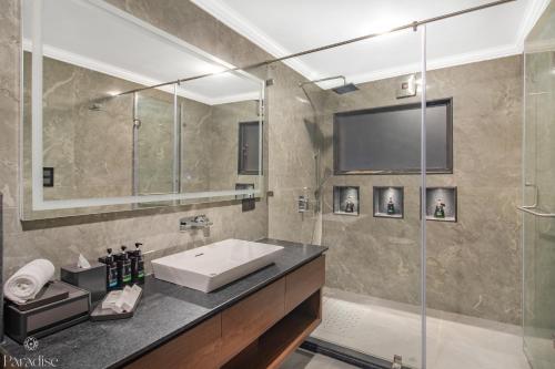 a bathroom with a sink and a shower at Paradise Hotels in Pahalgām