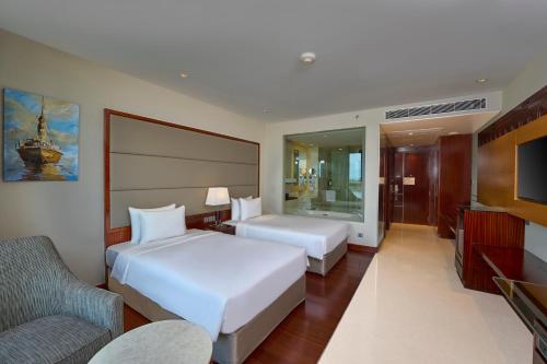 a hotel room with two beds and a tv at Crowne Plaza Kochi by IHG in Cochin