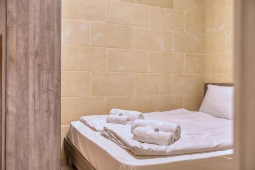 two towels on a bed in a room at Staytopus Offshore Marsalforn Budget Room for Divers & Travelers in Marsalforn