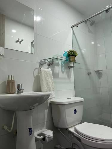 a white bathroom with a toilet and a sink at Apartamento COMPLETO Nuevo Norte de Valledupar-1 Habitación, Balcón y Parqueadero in Valledupar