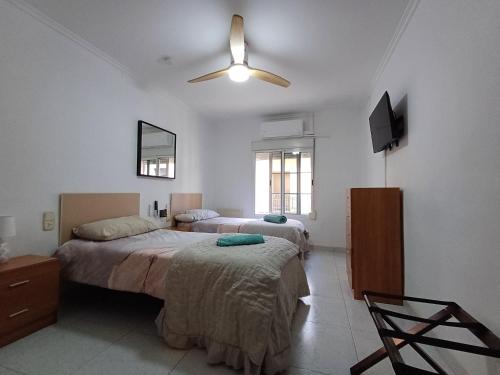 a bedroom with two beds and a flat screen tv at San Jose Luminoso in Algemesí