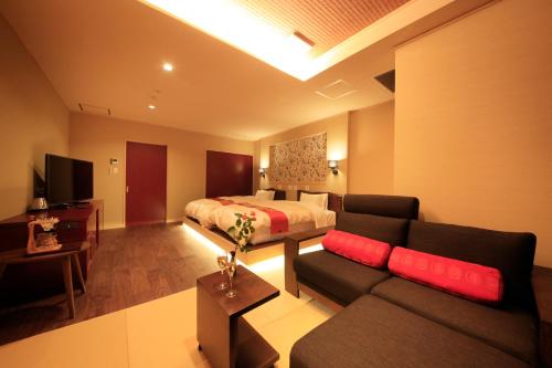 a living room with a couch and a bed in a room at Tensui Saryo in Hakone