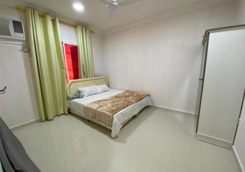 a small room with a bed and a window at RED Alwadi Salalah in Salalah