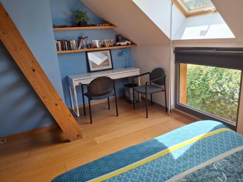 a bedroom with a table and chairs and a window at La Maison des Coeurs in Attignat-Oncin
