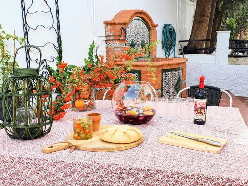 a table with a plate of food and a bottle of wine at Casa Rural con piscina privada y jardines - LA CASILLA in Cájar