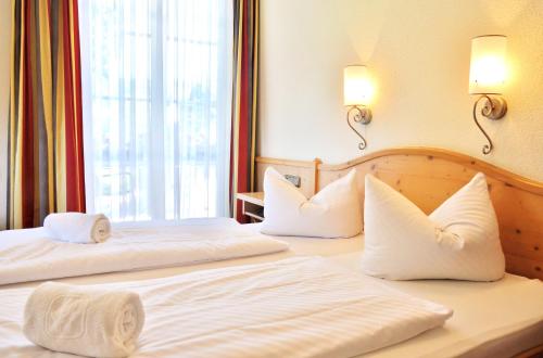 2 Betten in einem Hotelzimmer mit weißen Kissen in der Unterkunft Hotel Alttolkewitzer Hof in Dresden