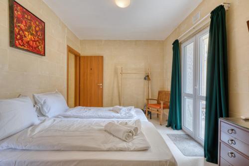 a bedroom with two beds and a window at Staytopus Offshore Marsalforn Budget Room for Divers & Travelers in Marsalforn