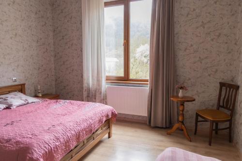 a bedroom with a pink bed and a window at Strawberry in Borjomi