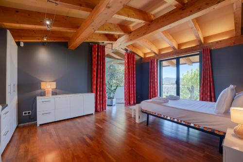 a bedroom with a large bed and red curtains at Flateli Villa Palau in Girona