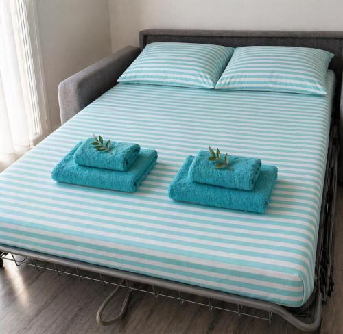 a bed with two blue towels on top of it at Studio Villa Loostic in Martigues