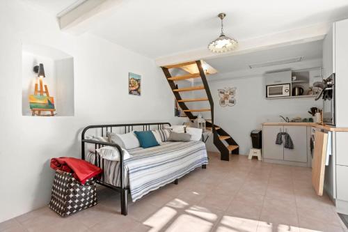 ein Wohnzimmer mit einem Bett und einer Treppe in der Unterkunft Bastidon Cotignac in Cotignac