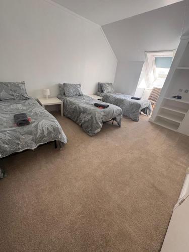 a bedroom with two beds and a couch at Cunninghame 3 in Beith