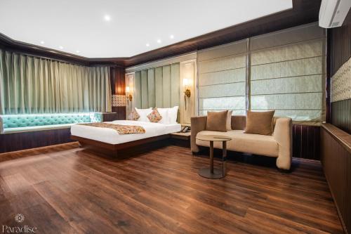 a hotel room with a bed and a couch at Paradise Hotels in Pahalgām