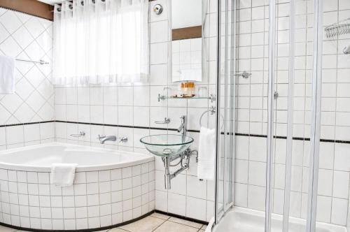 a bathroom with a tub and a sink at Protea Hotel by Marriott Windhoek Furstenhof in Windhoek