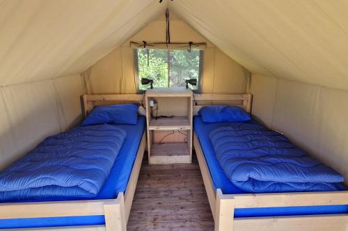 two beds in a tent with a desk at Glamping Drouwenerzand in Drouwen
