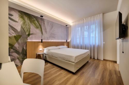 a bedroom with a bed and a tv and a chair at Monolocale 3 - viale Turati, Lecco in Milan