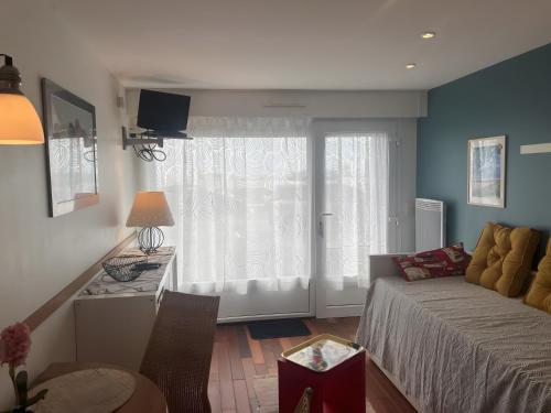 a living room with a couch and a window at Studio Face Mer in Quend-Plage