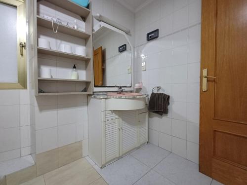 a white bathroom with a sink and a mirror at San Jose Luminoso in Algemesí