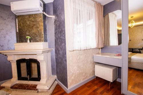 a living room with a fireplace and a bedroom at Cadde 7 Otel in Bahçelievler