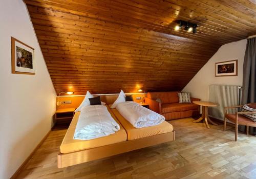 a bed in a room with a wooden ceiling at Hotel-Restaurant Gasthof Adler in Neuenburg am Rhein