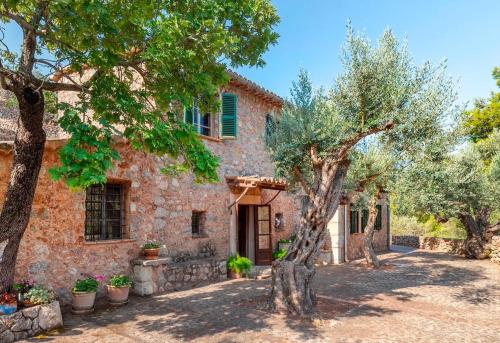 an old stone house with trees in front of it at Es Coco Mountain Cottage in Sóller by PriorityVillas in Port de Soller