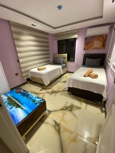 two beds in a room with a painting on the floor at Avullar Palace Hotel in Antalya